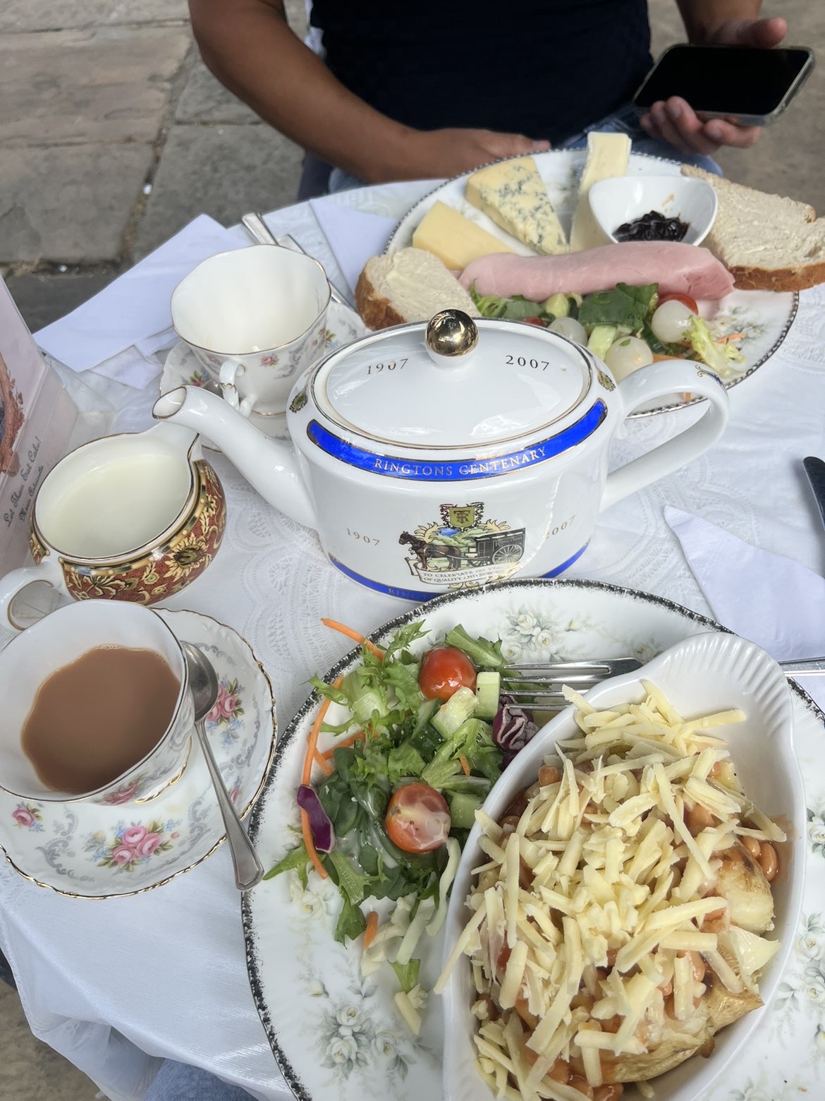 Lunch and a teapot served on a courtyard table